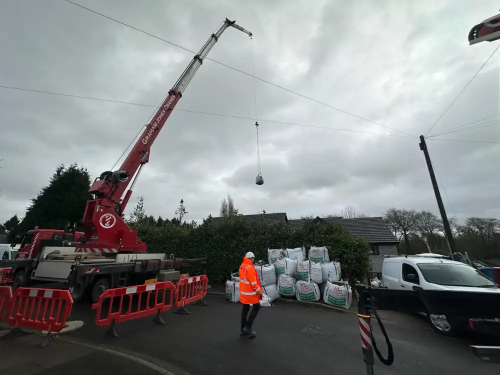 Crane lifting materials into a big house build in Worsley